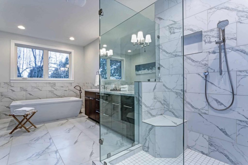 Walk-in shower with glass enclosure and marble tile
