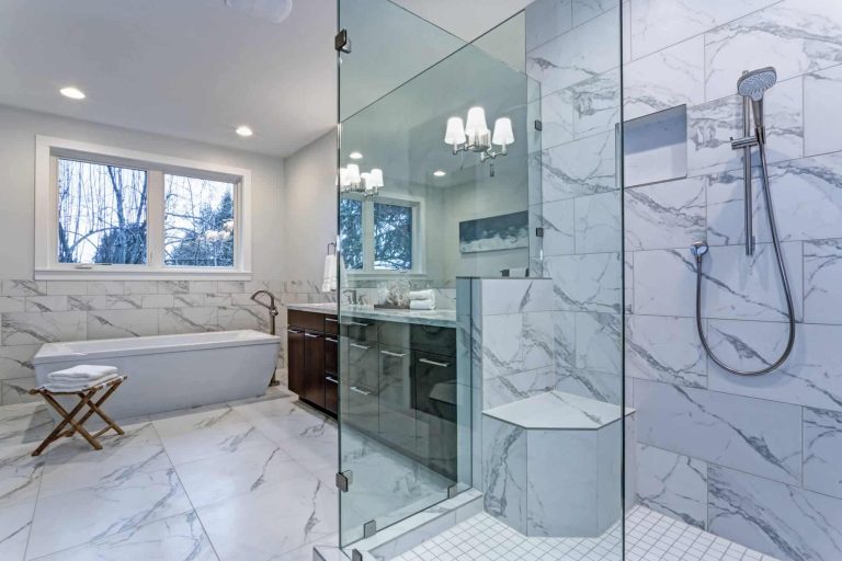 Walk-in shower with glass enclosure and marble tile